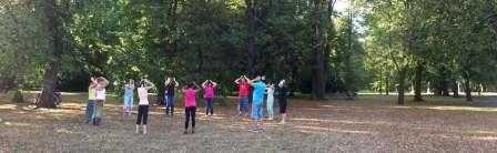 Skupinka cvičících Tchaj-ťi v parku pod stromy